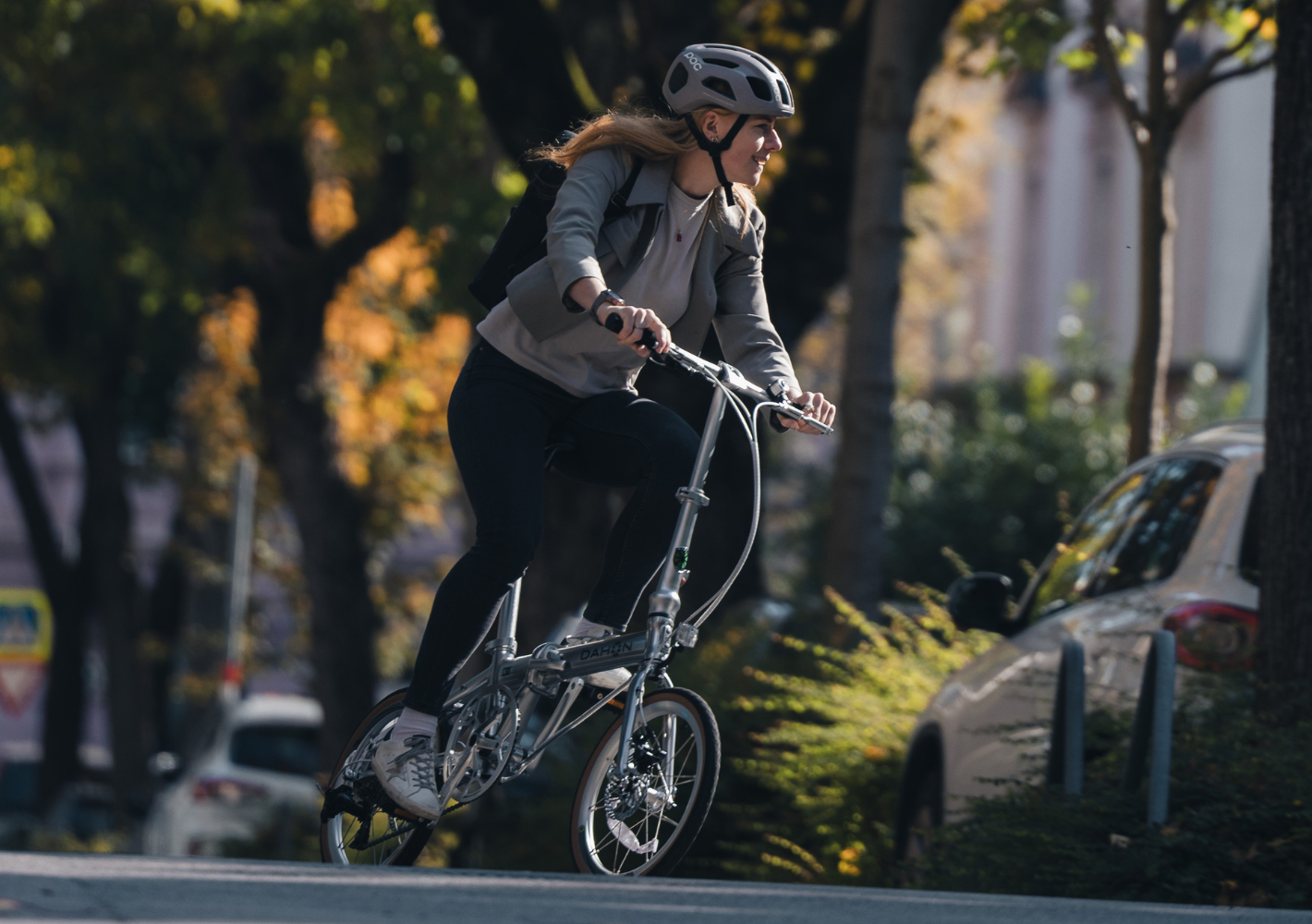 Eine Radfahrerin nutzt ein Faltrad für den Weg durch die Stadt zwischen Bahnhof und Geschäftstermin.