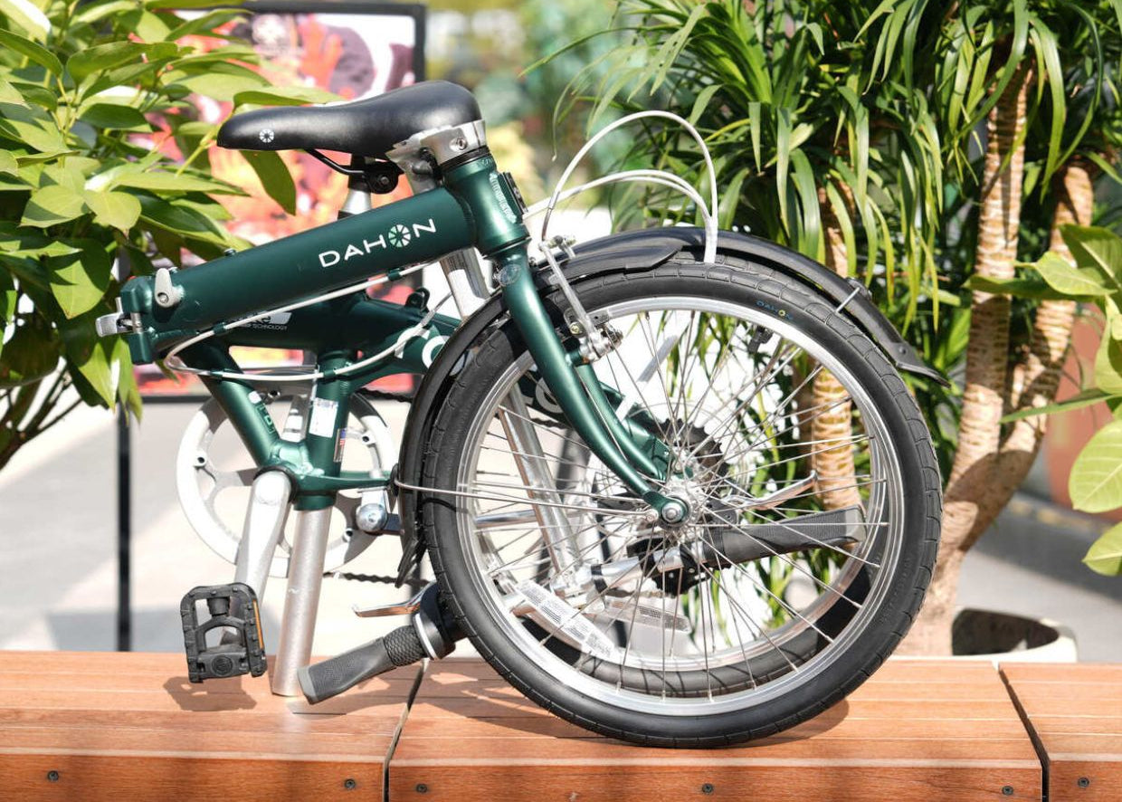 Route - Dark green Dahon Route foldable bicycle with aluminum frame, black saddle and silver crankset, partially unfolded outdoors.